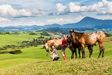 Two girls with a horse on a field in Slovakia