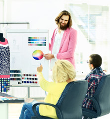 modern designer and his team choose the fabric for clothes
