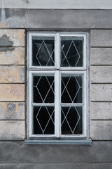 The white wooden window with grate in one of the houses