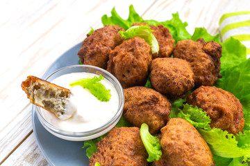 Acaraje or akara snack with green salad and sour cream