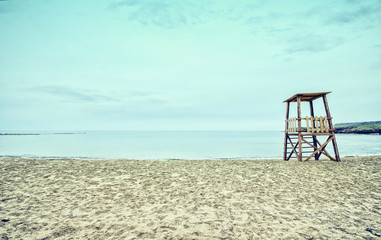 Empty sandy beach with lifeguard tower, Crete, Greece.