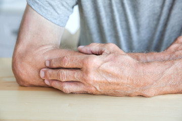 Senior man sitting at table, closeup