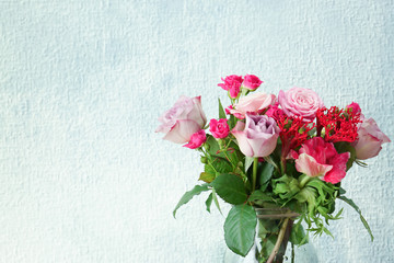 Glass vase with beautiful bouquet of  flowers on light background