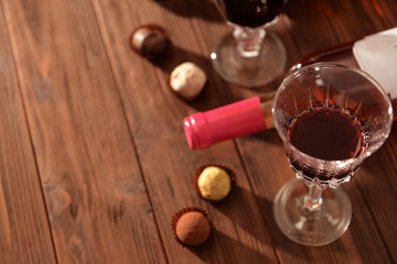 Wine and chocolates on wooden background