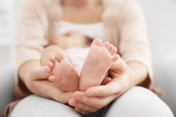 Obraz na płótnie Canvas Mother holding cute baby on her knees, closeup