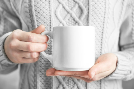Woman holding blank cup for branding in hands