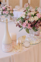 Beautifully decorated bouquet of roses with champagne and candles