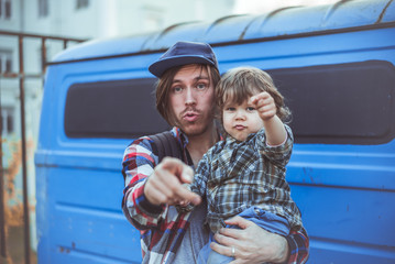 Папа и сын в клетчатых рубашках на руках крутые смотрят в камеру