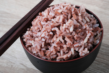 Stream brown rice in bowl and chopstocks