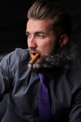 Attraktiver Mann mit Zigarre und Vollbart
