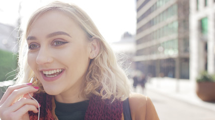 Fototapeta premium Attractive young woman on an escalator checking her phone, with space for text
