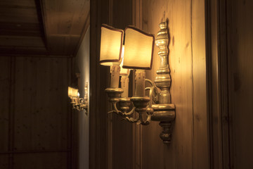 antique style lights on the wall. it pretends the candle lights in middle ages but there's light bulb.