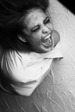 screaming crazy young woman in straitjacket, monochrome