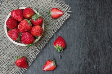 Fresh strawberry in wooden bowl on the table