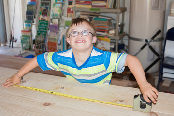Boy With Downs Syndrome Playing With Measuring Tape