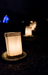 Christmas Eve candle lights in paper bags at night with blue tree