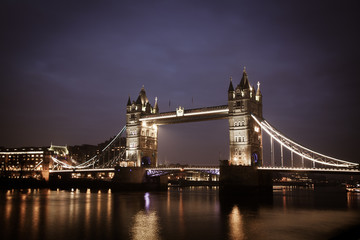 the iconic Tower Bridge of London lit up at night over the River Thames