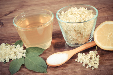 Vintage photo, Flowers and juice of elderberry, ingredients for preparing beverage on rustic board