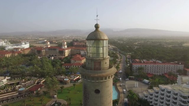 Aerial shot of Gran Canaria coast. Tourist town with resorts and Maspalomas Lighthouse