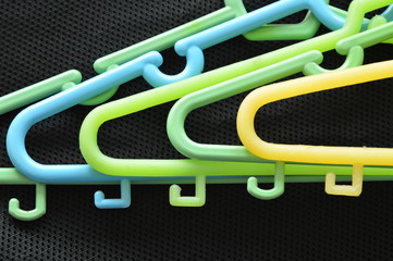 colorful plastic clothes hunger overlay on black fabric