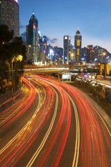 Naklejka premium Night traffic and skyline of Hong Kong city at dusk