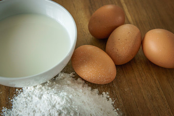 egg,flour,milk on wood table