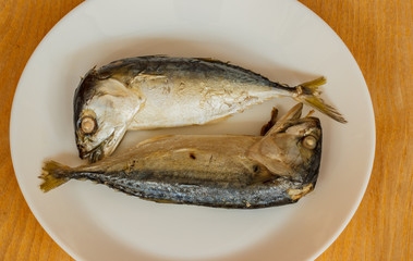Mackerel, Steamed on plate white lay on the wooden floor.