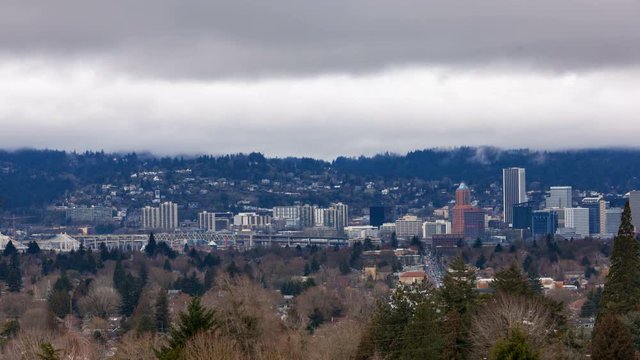 Timelapse movie of moving low white clouds over city skyline and auto traffic downtown Portland Oregon one winter day 4k ultra high definition uhd