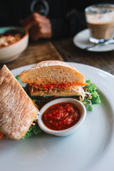 The plate of sandwich with vegetables and red sauce