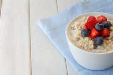 Bircher Muesli with Fresh Strawberries and Blueberries on Top with Copy Space Horizontal