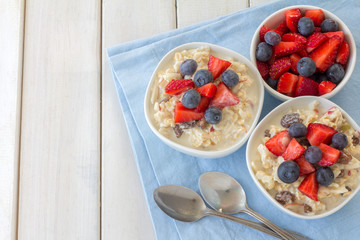 Bircher Muesli with Fresh Berries on White Wooden Table from Above with Copy Space
