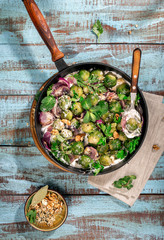 Roasted sprouts in cast iron pan on wooden table