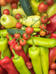 Green pepper, red tomatoes and cucumbers. Vegetables photographed from the top. Large group of fresh vegetables top view.