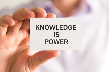 Businessman holding a card with KNOWLEDGE IS POWER message