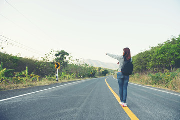 Obraz premium young women happy walking on the road at mounthain and sunet