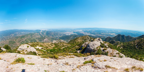 Panoramic views of the valley from the mountains of Montserrat. Near Barcelona, Spain. Beautiful nature in shades of green on a background of blue sky