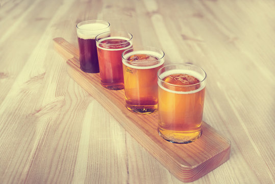 Beer tasting. Diferent beer in 100 mililiter glases over wooden table.