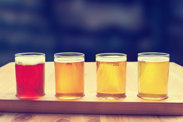 Beer tasting. Diferent beer in 100 mililiter glases over wooden table.