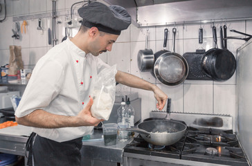 chef cooking pasta dish Parmesan, pan cooker, commercial kitchen