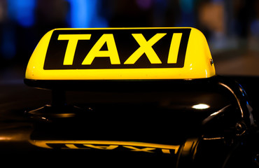 Taxi sign on the roof of a car at night