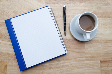 coffee with notebook on wooden table, view from above