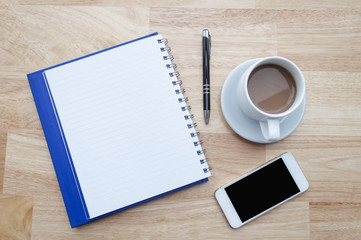 coffee with notebook,smartphone on wooden table, view from above
