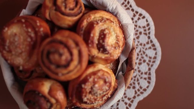 ruddy crispy rolls, Full sweet bread, hot cakes, cinnamon  sesame seeds, flower pattern
lace doily, homemade tablecloth, camera motion, rack focus overhead shot, 
