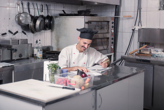 happy smiling young chef writing ordering kitchen