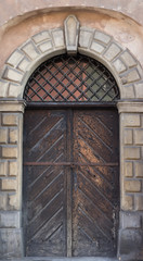 Old wooden brown door close-up with insertions and patterns on glass