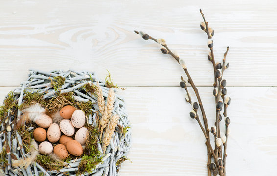 Easter eggs in nest over wooden background. View with copy space