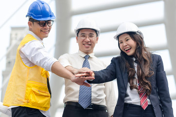 Group of architects team touching hands together. Selective focus.