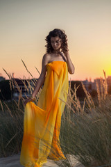 Obraz premium Portrait of a beautiful woman on the beach at sunset