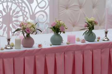 Roses in a vase and candles on the table. Wedding decorations