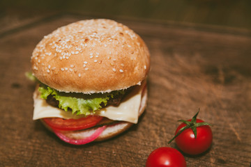 juicy burger and tomatoes on the board